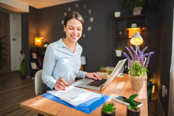 Ambitious young woman sitting at desk working at home